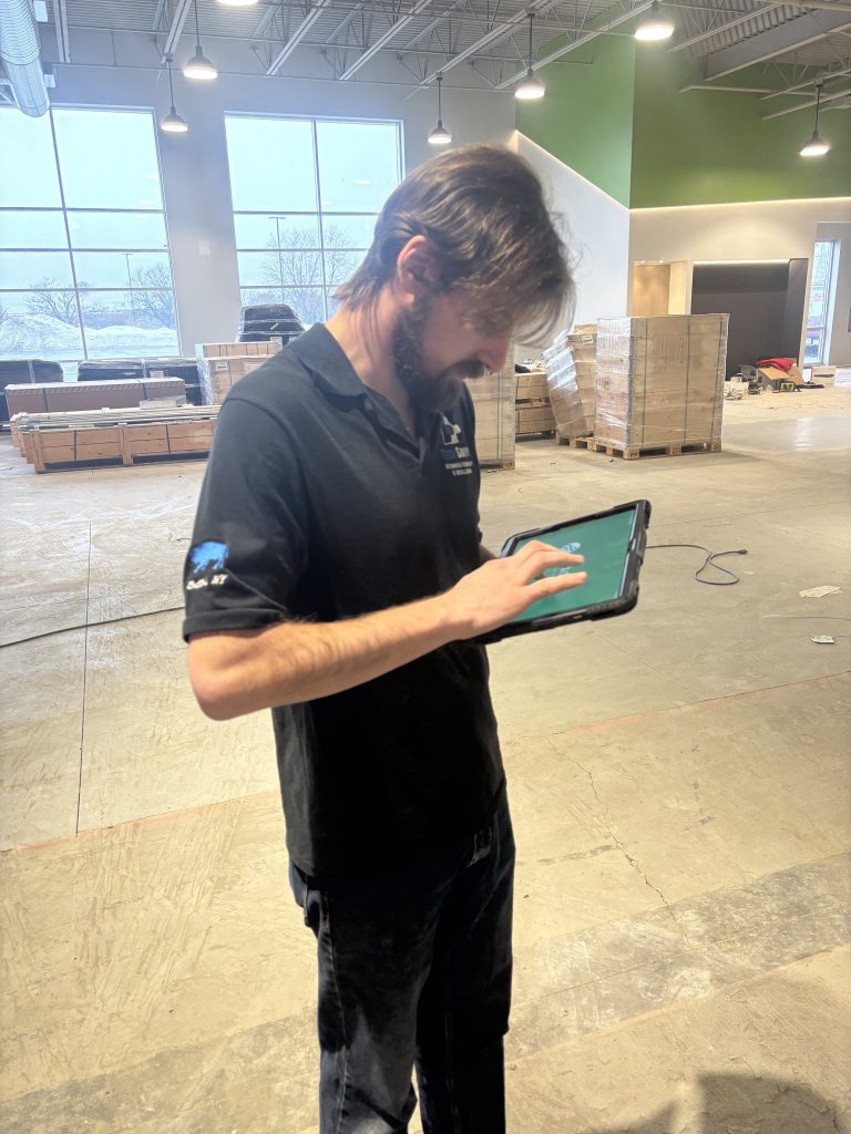Technician using iPad to control camera system for Buffalo gym